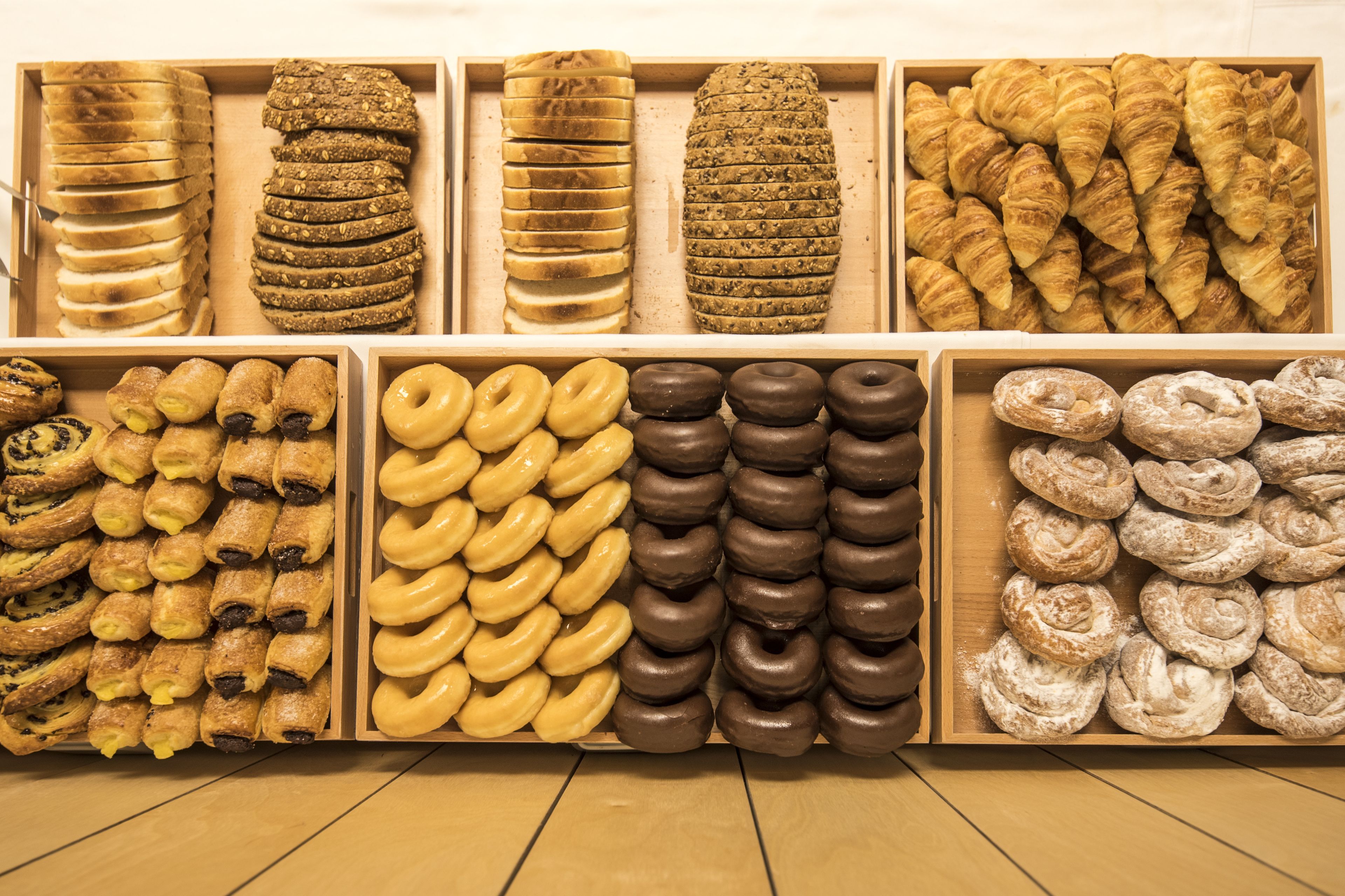 A bakery display with various types of pastries and donuts.