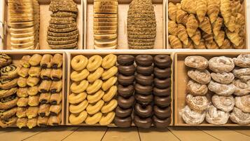 A bakery display with various types of pastries and donuts.