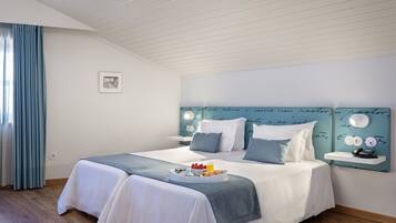 A bedroom with a bed, bedside tables, a headboard with writing, a picture on the wall, and a window with curtains.