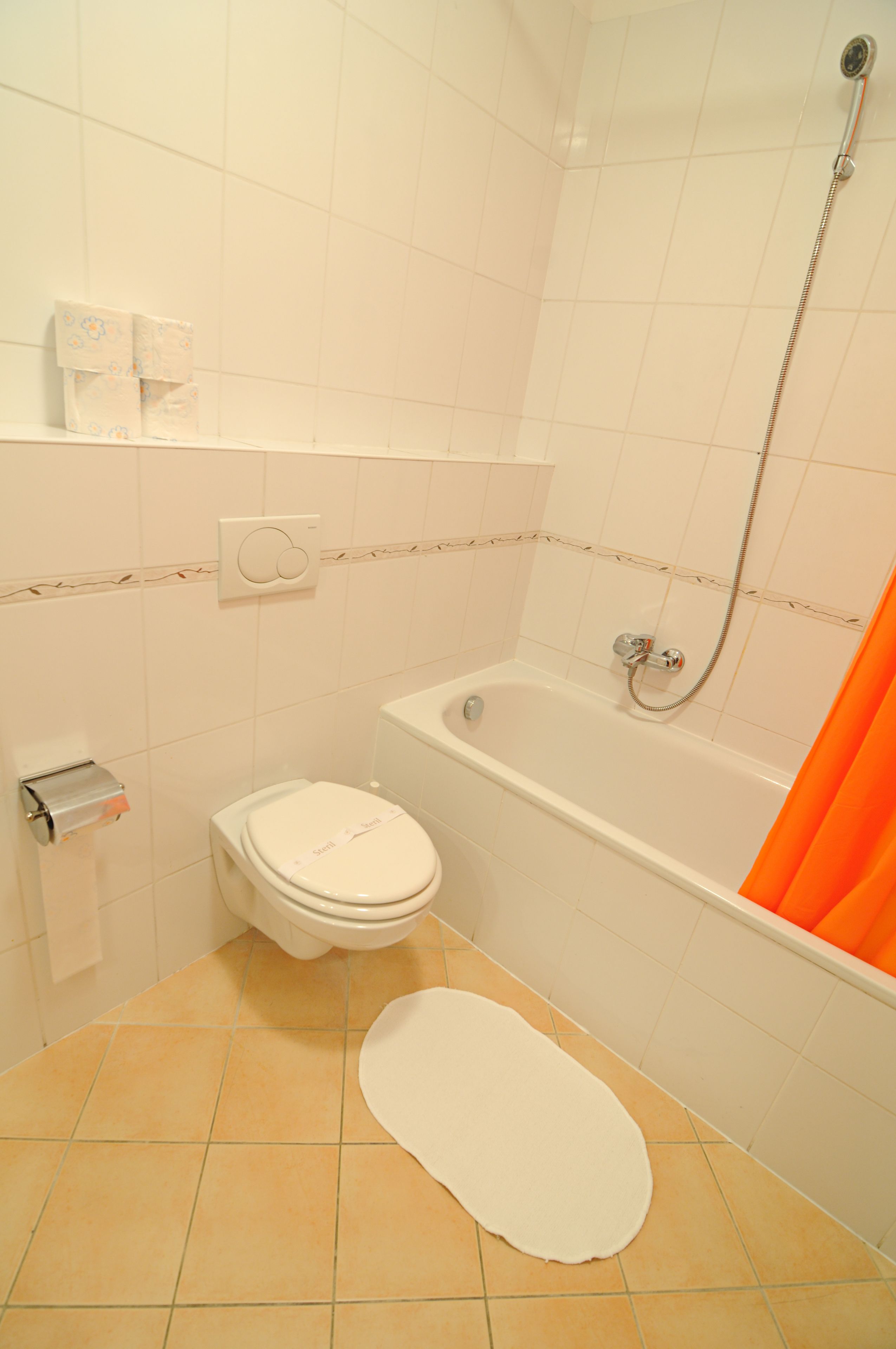 A bathroom with a toilet, a bathtub, and a shower.
