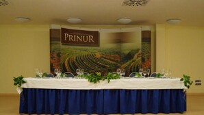 Una mesa de conferencias dispuesta en una sala, con un cartel que dice "BODEGA PRINUR" al fondo.