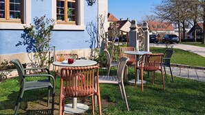 A building with outdoor seating, a garden, and a clear sky. - Gasthof Hotel Bezold (Rothenburg ob der Tauber)