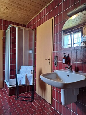 A bathroom with a shower, a sink, and a mirror. - Gasthof Hotel Bezold (Rothenburg ob der Tauber)