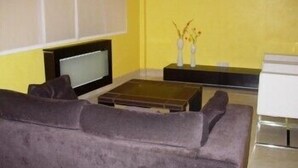 A living room with a sofa, a flat-screen TV, a coffee table, and a decorative vase. - Hotel Arteixo (Arteixo)