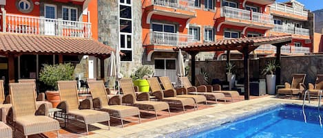 Piscina a l'aire lliure, para-sols i gandules