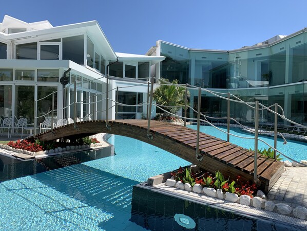 Een binnenzwembad, 2 buitenzwembaden en parasols bij het zwembad