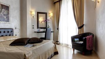 Una habitación de hotel con una cama grande, un escritorio, una silla y una ventana con cortinas.