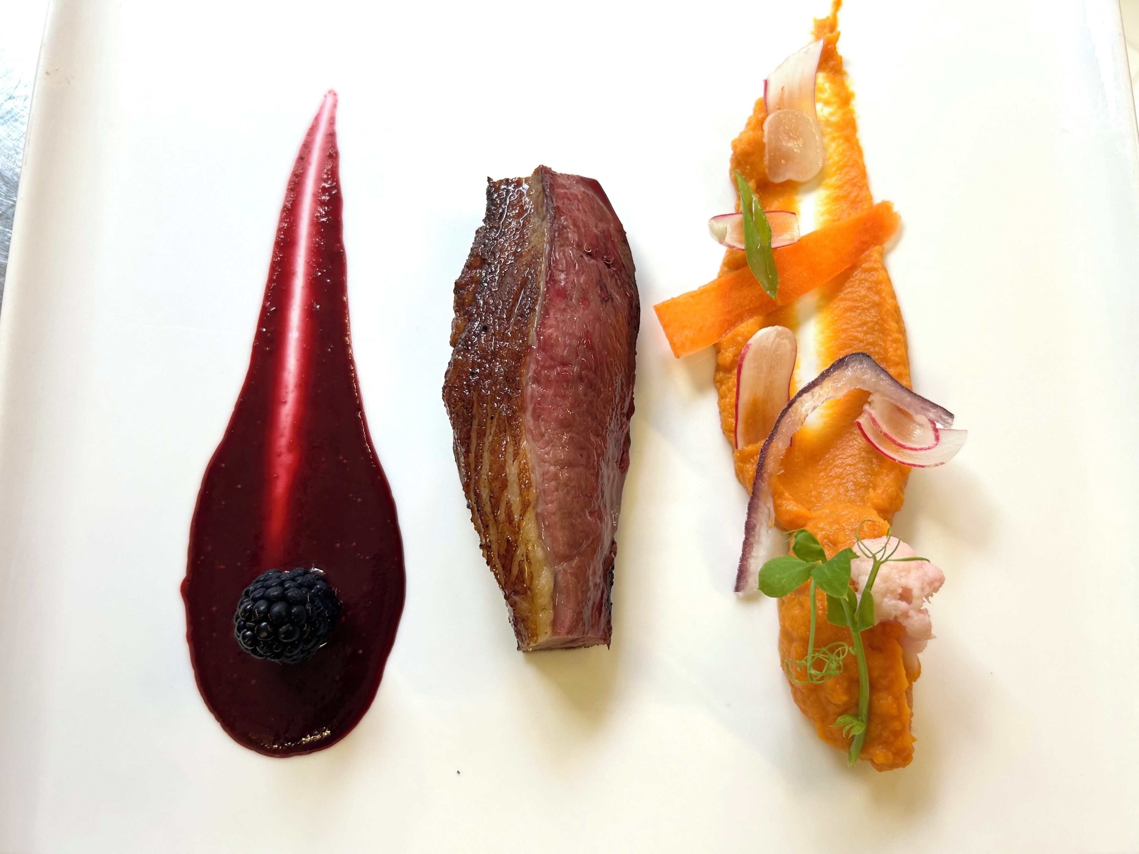 Three distinct food items on a white plate.