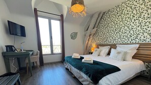 Une chambre à coucher avec un lit, un bureau, une chaise, une télévision et une fenêtre.
