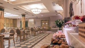 A hotel dining area with checkered floor tiles, wooden chairs, and tables. - Dorma Reina Isabel (Ávila)