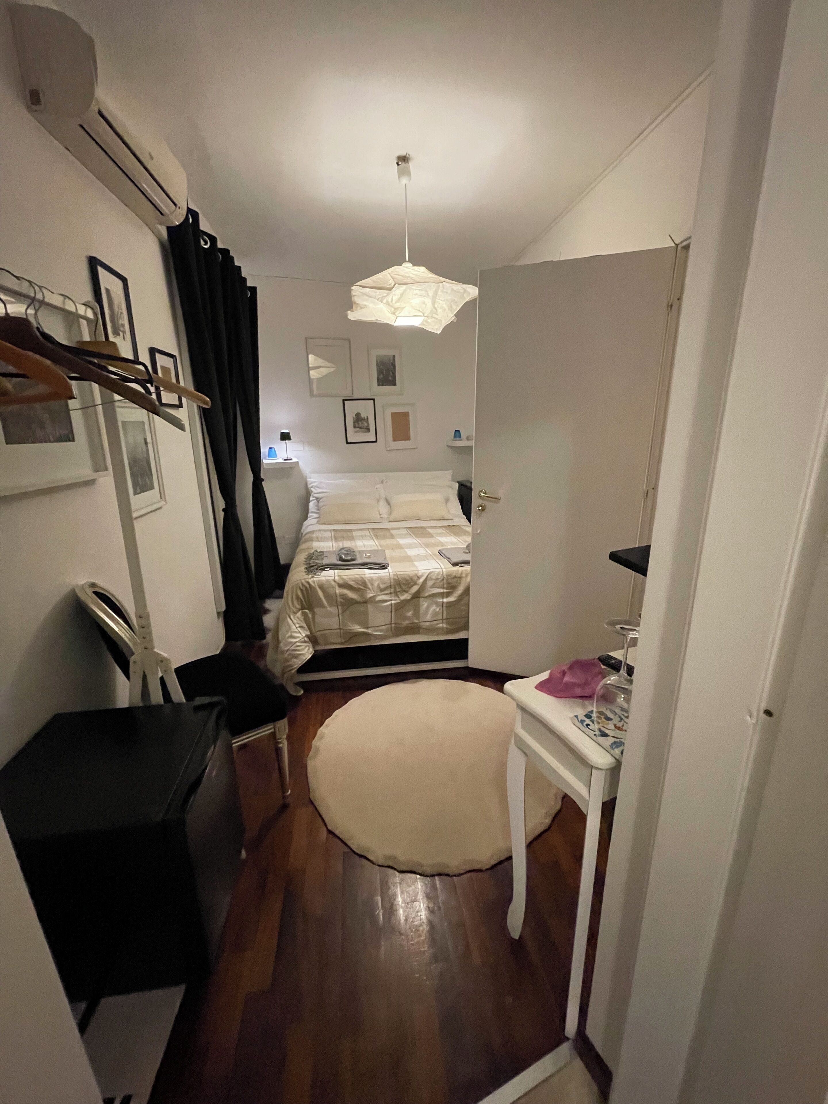 Un dormitorio pequeño y acogedor con cama, mesita de noche y escritorio con silla.