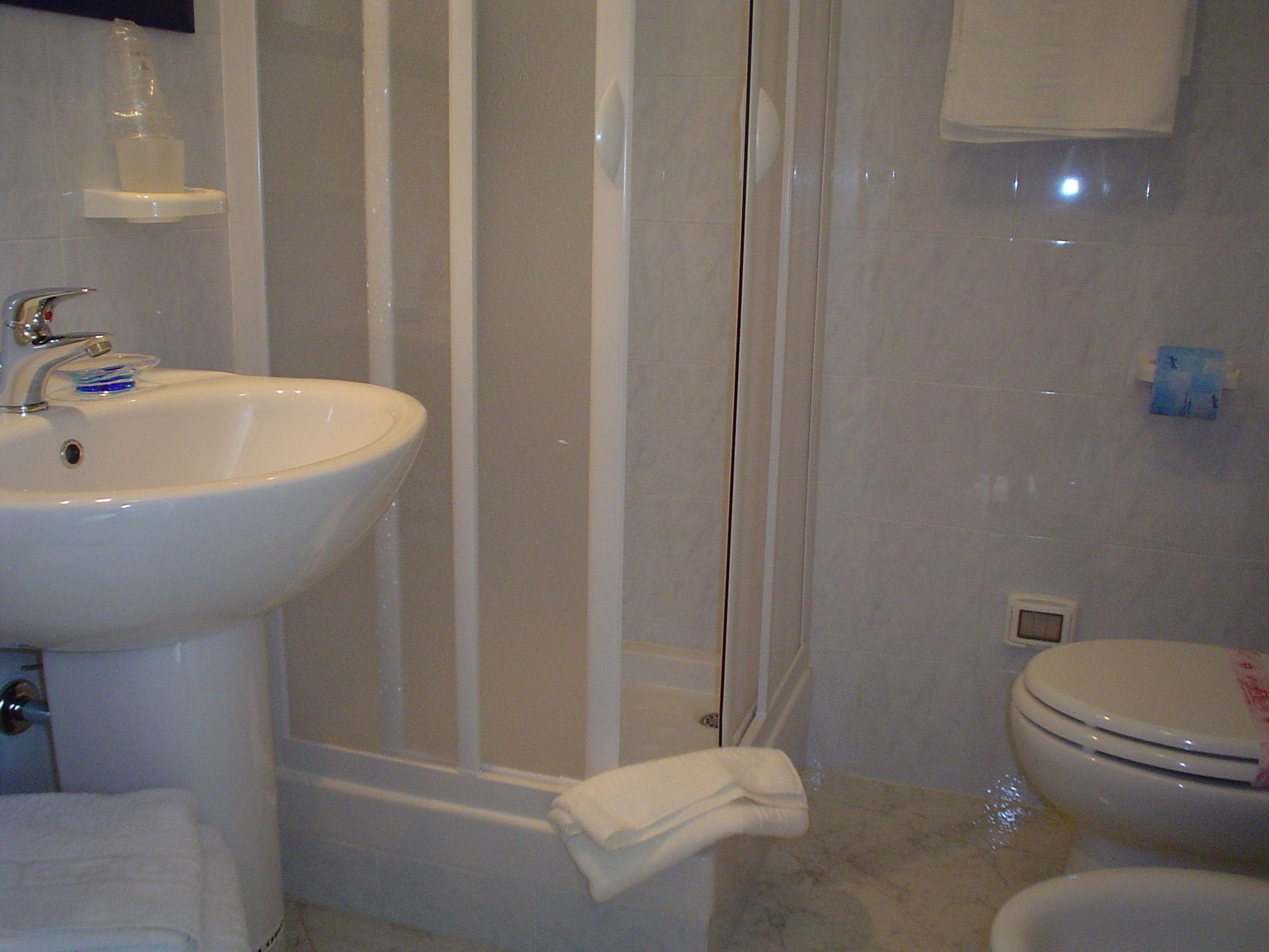 A bathroom with a sink, toilet, and shower.