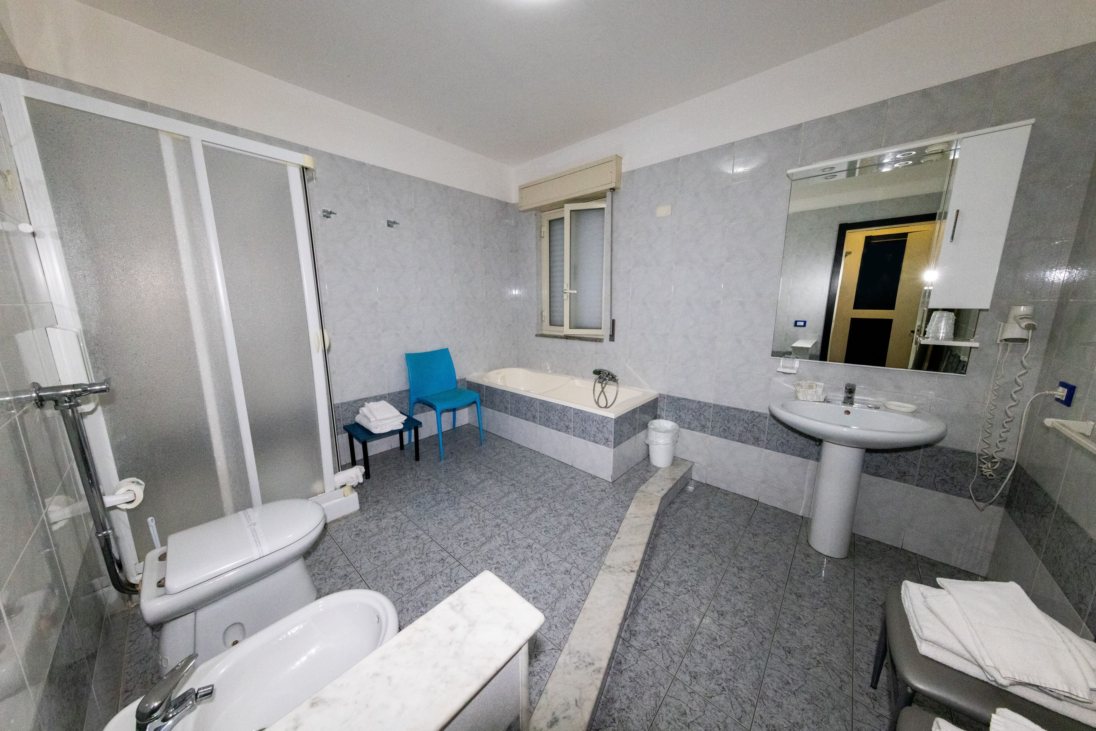 Une salle de bain moderne équipée de toilettes, d’une baignoire, d’un lavabo et d’un miroir.