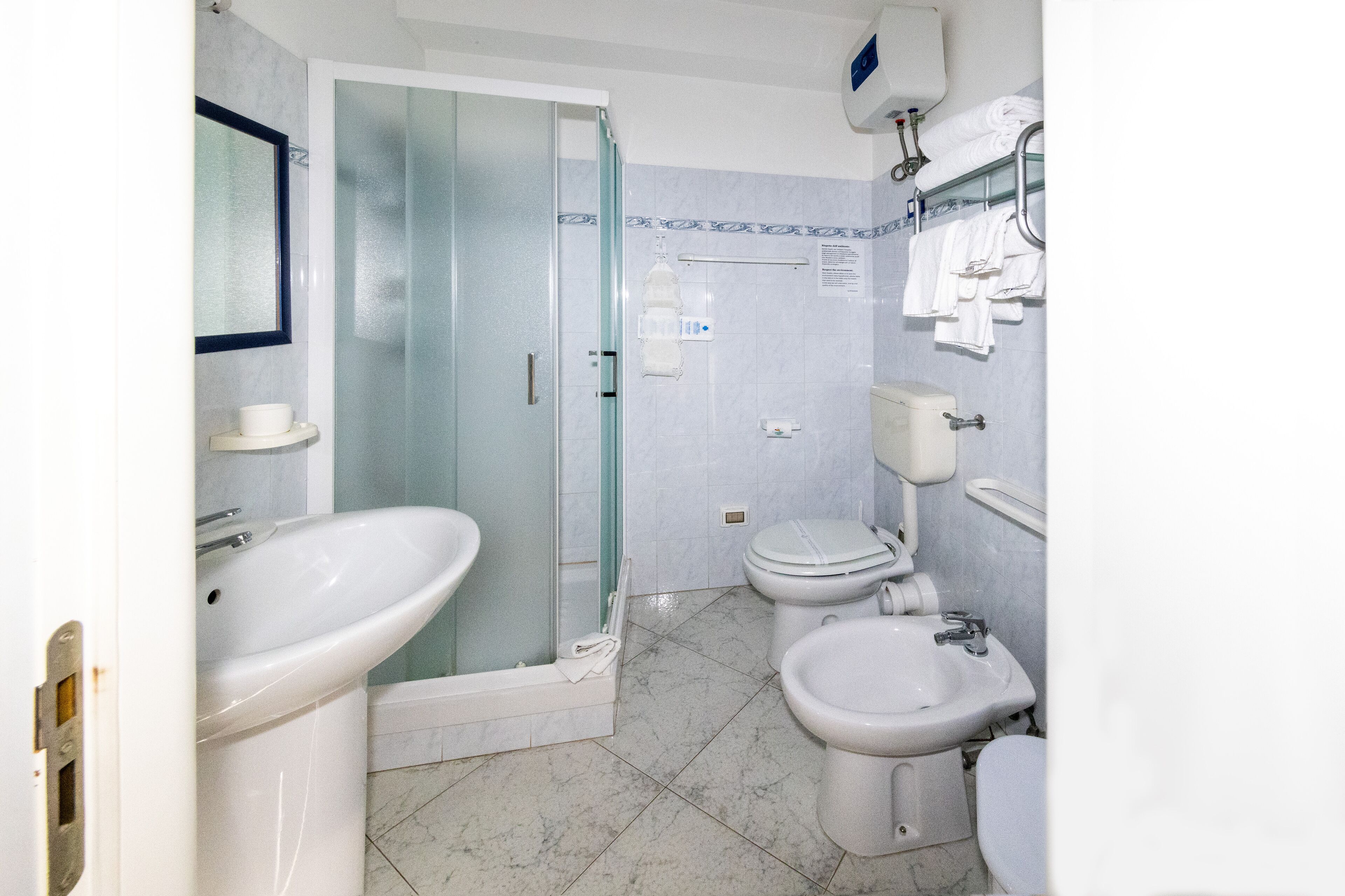 Ein Badezimmer mit einer Duschkabine, Toilette, Bidet und Waschbecken.