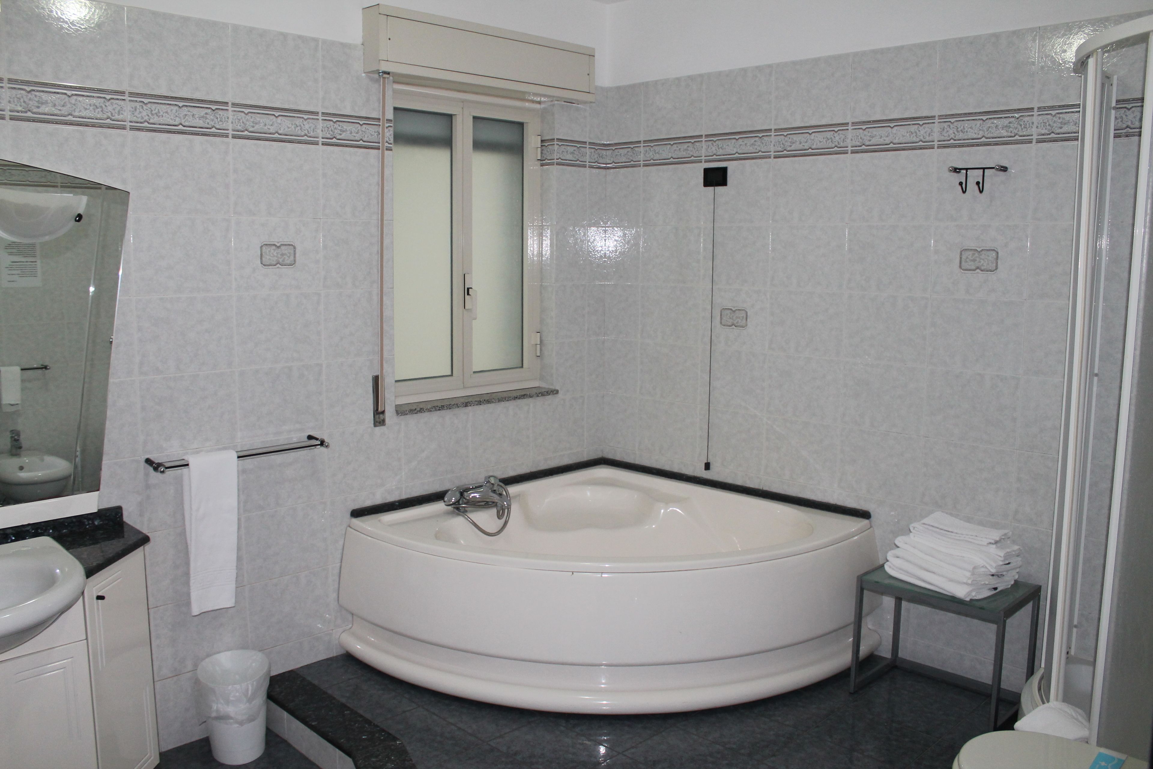 Un baño con una bañera independiente, un lavamanos y un inodoro.