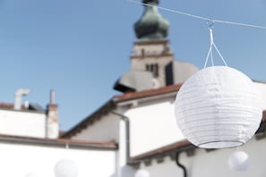 A white paper lantern hanging outdoors with a building in the background. - Hotel Mühldorf (Muhldorf am Inn)
