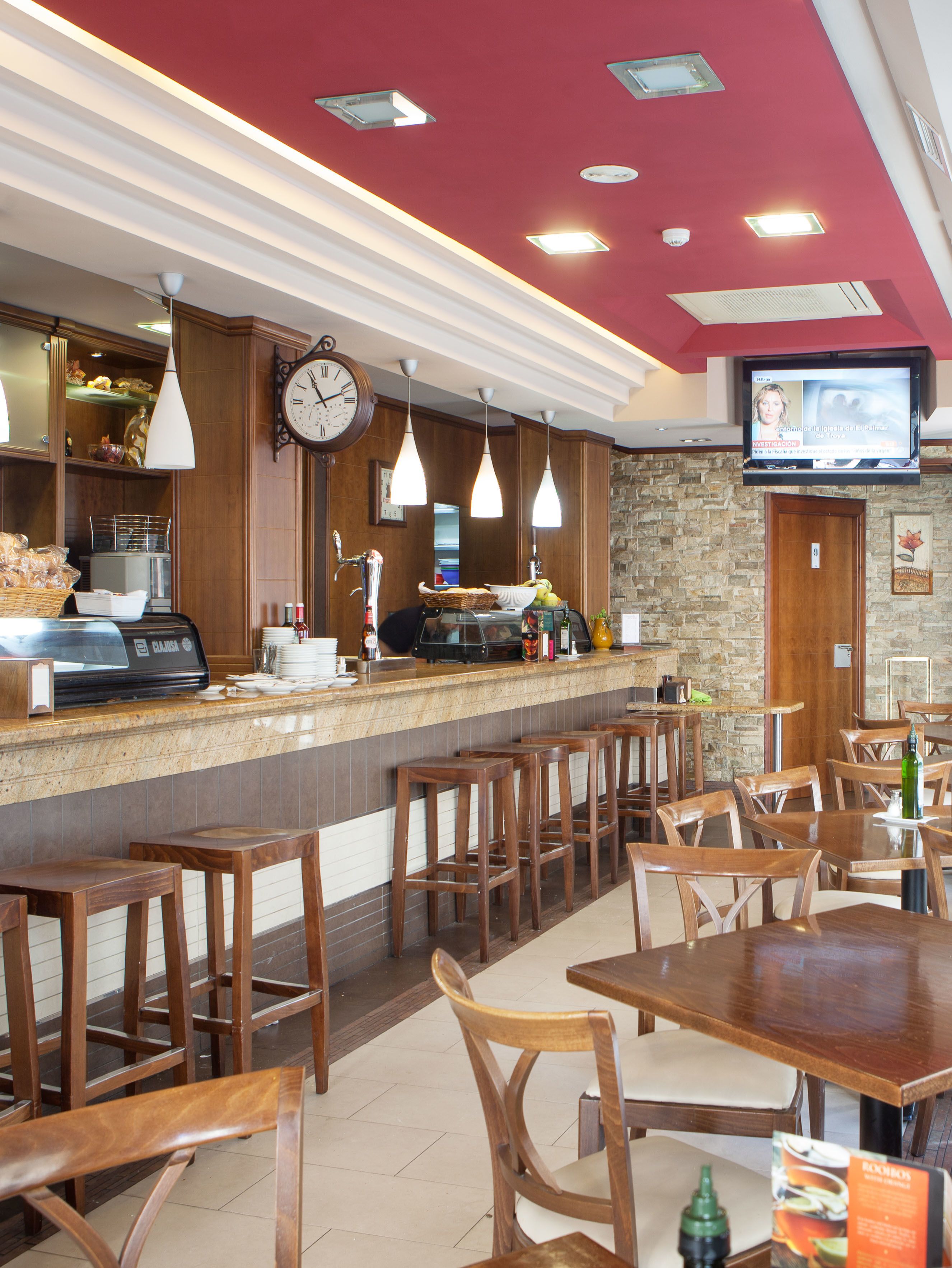 Un restaurant doté d’un bar, de chaises et de tables en bois.