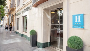 Un hotel con un letrero grande que dice "HOTEL" y "CASTILLA GERRERO" en la fachada. A la derecha, hay un letrero azul con una "H" y la palabra "CIUDAD".