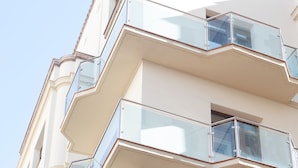 Un edificio de varios pisos con balcones y ventanas amplias.