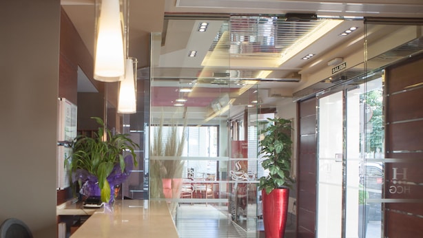 Una sala de conferencias moderna con una mesa larga, paredes de vidrio y plantas en macetas.