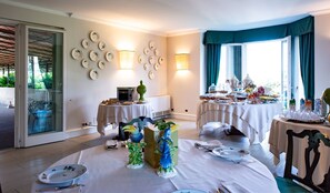 A dining area with round tables set for breakfast, decorated with plates and a centerpiece. - Hotel Franceschi (Forte dei Marmi)