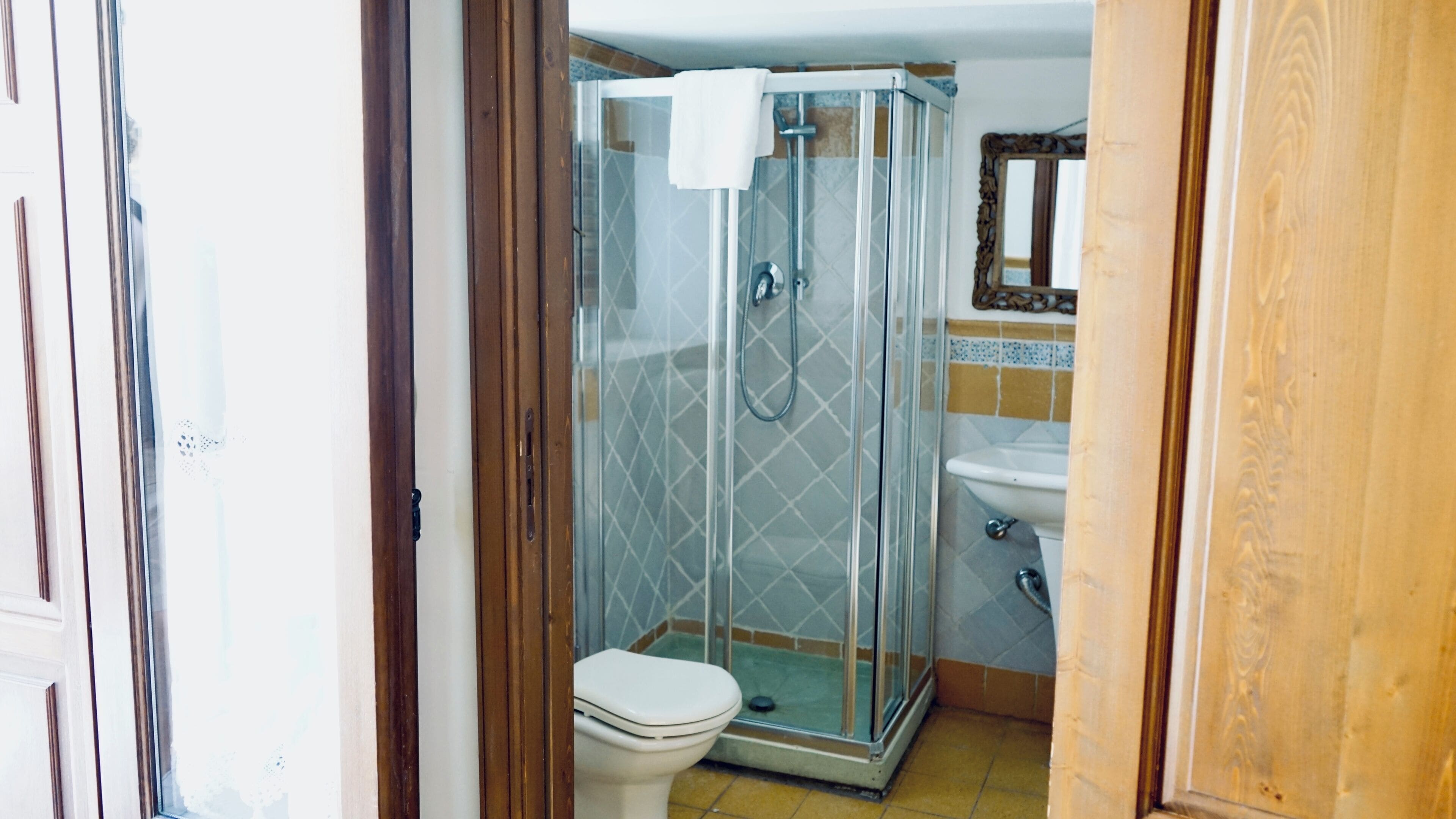 Un área de ducha con paredes de vidrio, un inodoro y un lavabo.