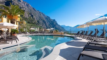 Una piscina al aire libre de temporada, sombrillas