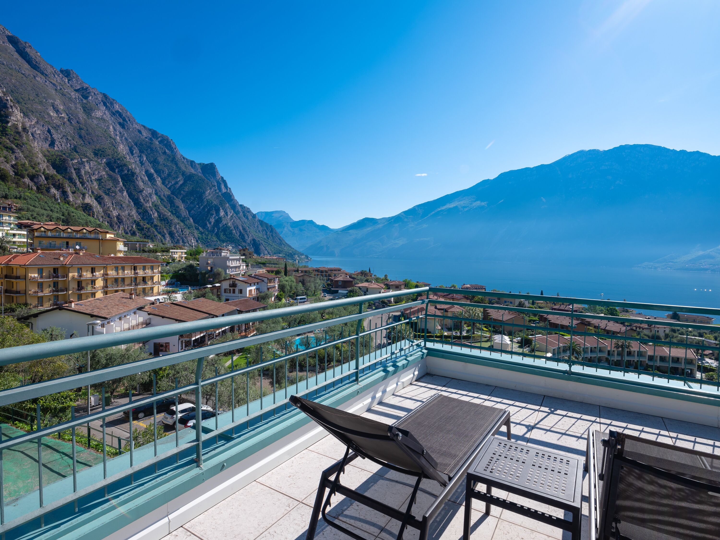 A balcony with a view of a mountainous landscape and a lake.