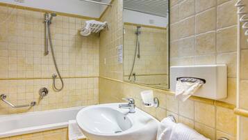 Un bagno con vasca, lavandino e doccia.