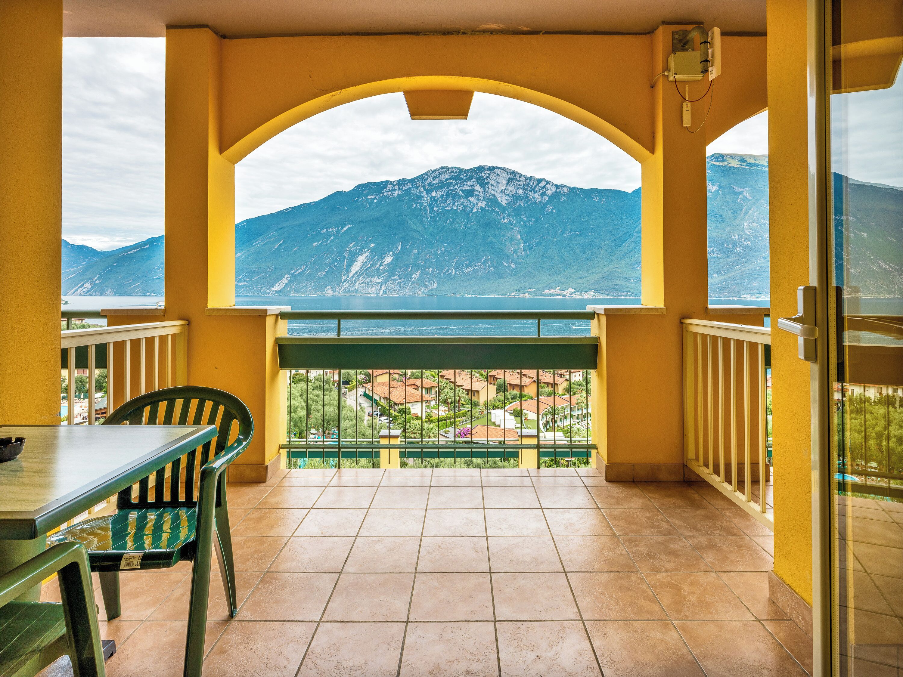 Un balcón con vistas a montañas y un lago.