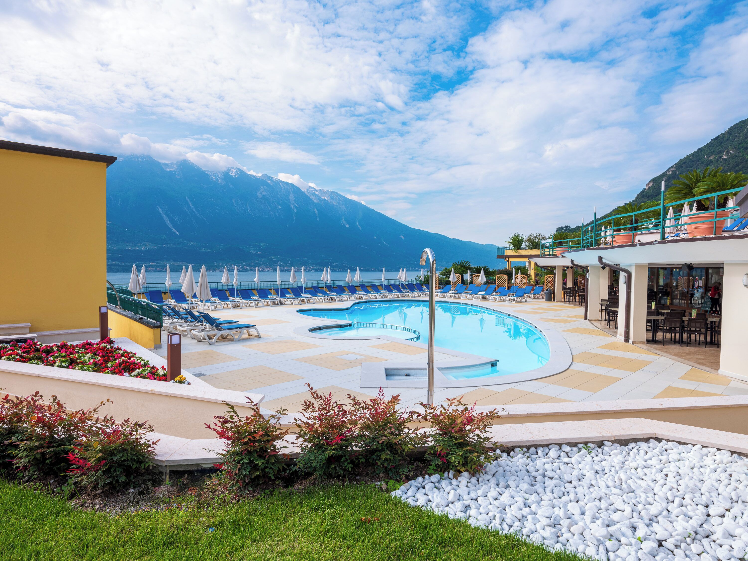 Ein Poolbereich mit Liegestühlen und Blick auf die Berge.
