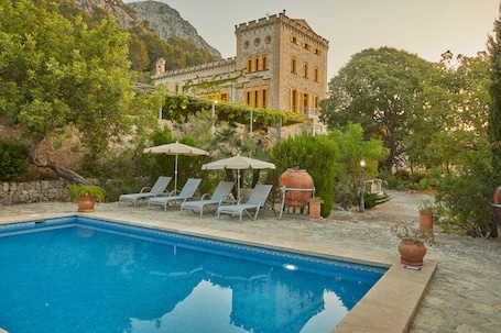 Una piscina al aire libre, sombrillas, sillones reclinables de piscina. Agritourismo Alquería Blanca