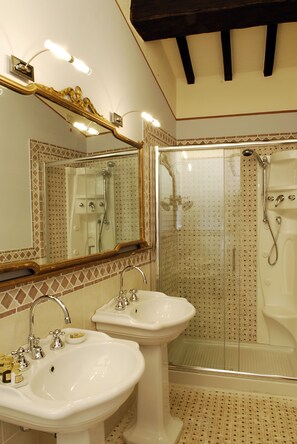 A bathroom with two sinks, a large mirror, and a glass-enclosed shower area. - Locanda del Molino (Cortona)