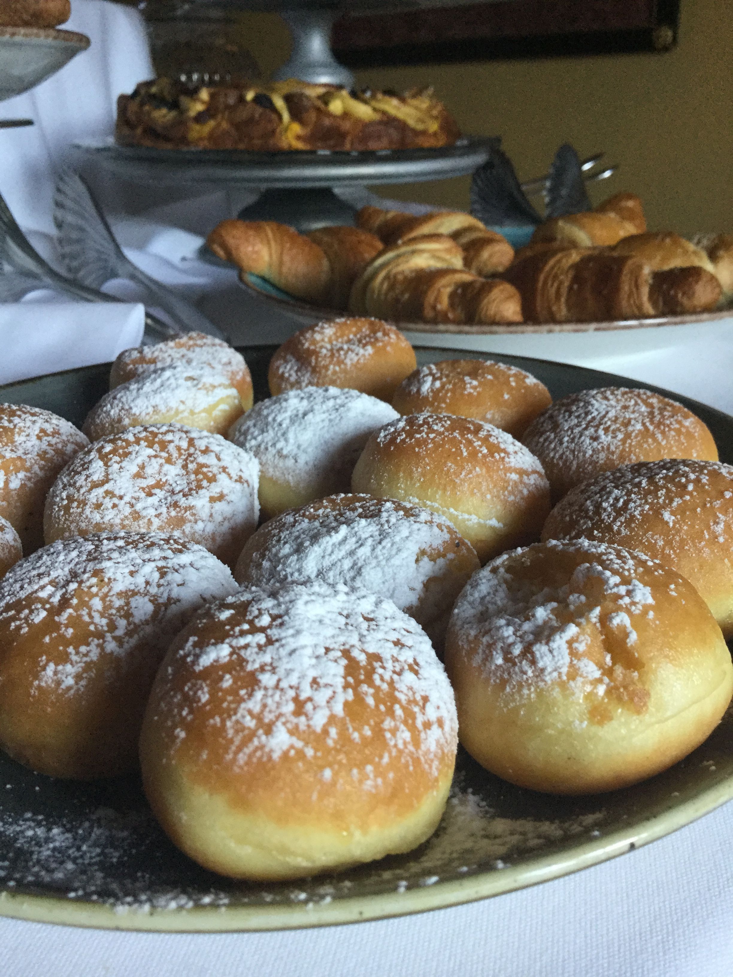 A tray of round pastries dusted with powdered sugar.