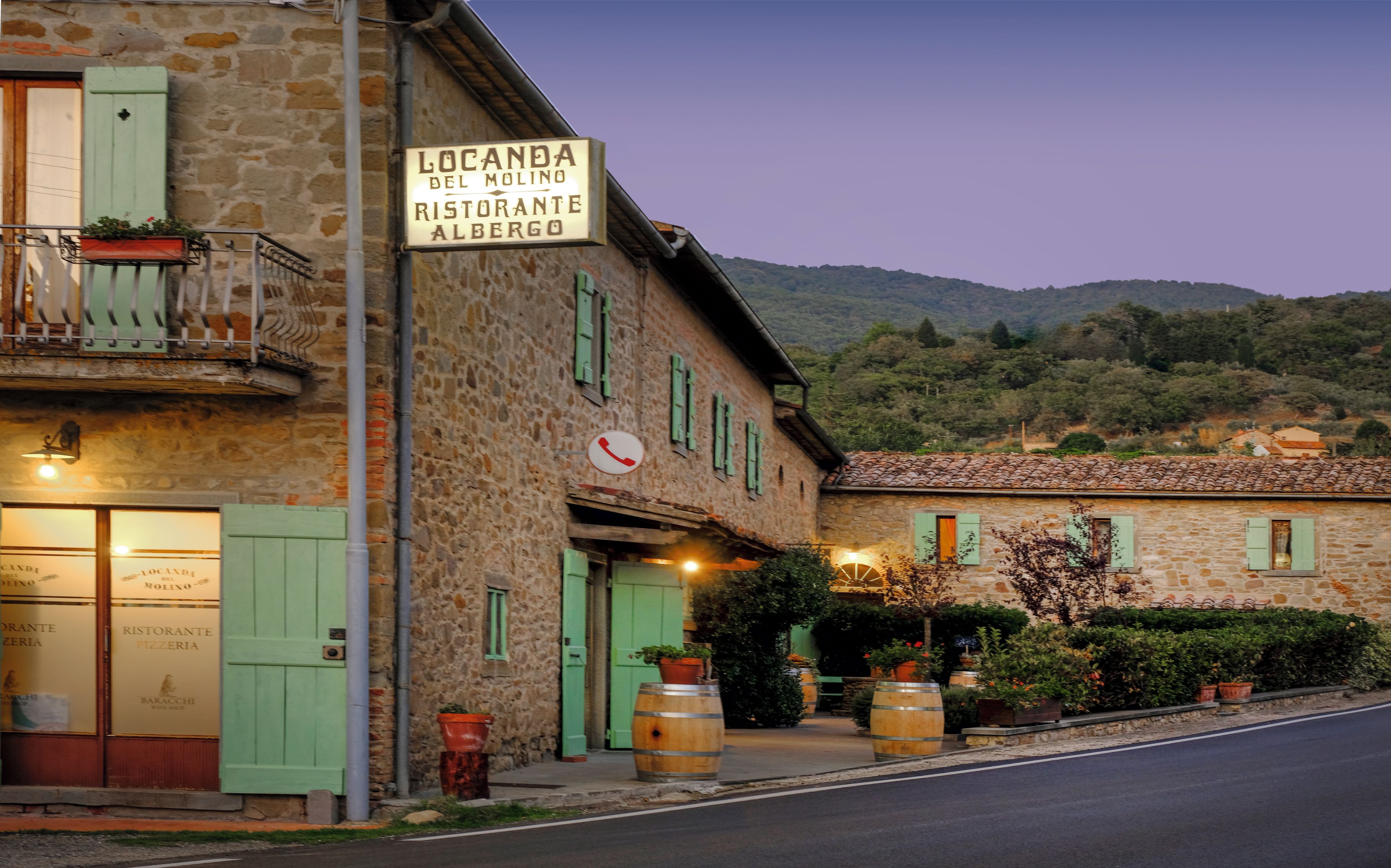 A stone building with a sign for 'Locanda del Molino Ristorante Albergo' and a rustic exterior.