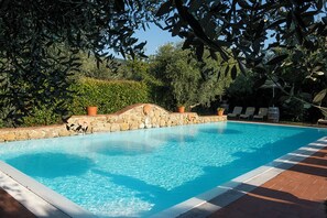 Una piscina al aire libre, sombrillas, tumbonas