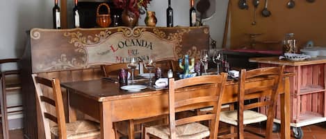 Un comedor rústico con muebles de madera y un letrero que dice "Locanda del Molino".