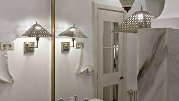 Een badkamer met twee wastafels, een grote spiegel en decoratieve lampen.