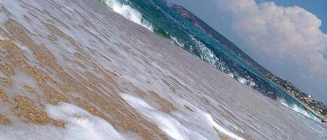A beach with waves approaching the shore.