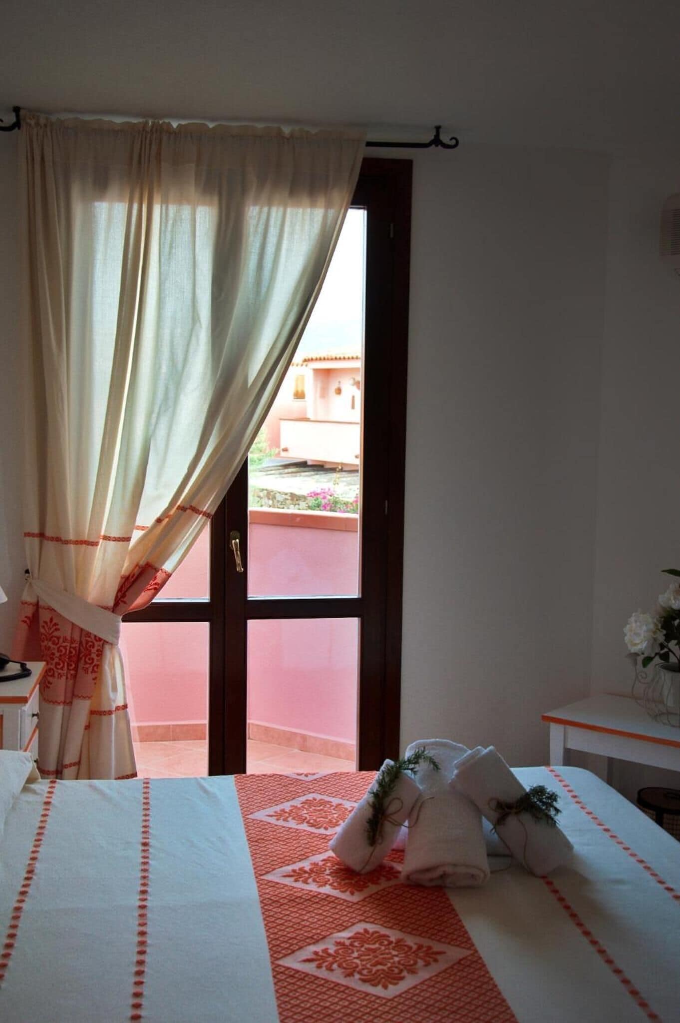 Quarto de hotel com cama, escrivaninha e vista para o exterior.