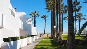 Un chemin menant à un bâtiment blanc, d’où l’on a une vue sur la mer.