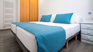 Une chambre à coucher avec un lit, une table de chevet, une armoire en bois et un radiateur blanc.