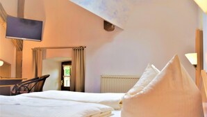 Une chambre d’hôtel avec deux lits, un téléviseur à écran plat, un bureau et une chaise.