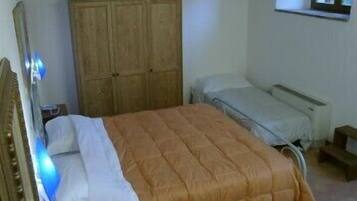 A bedroom with a bed, a wardrobe, and a window.
