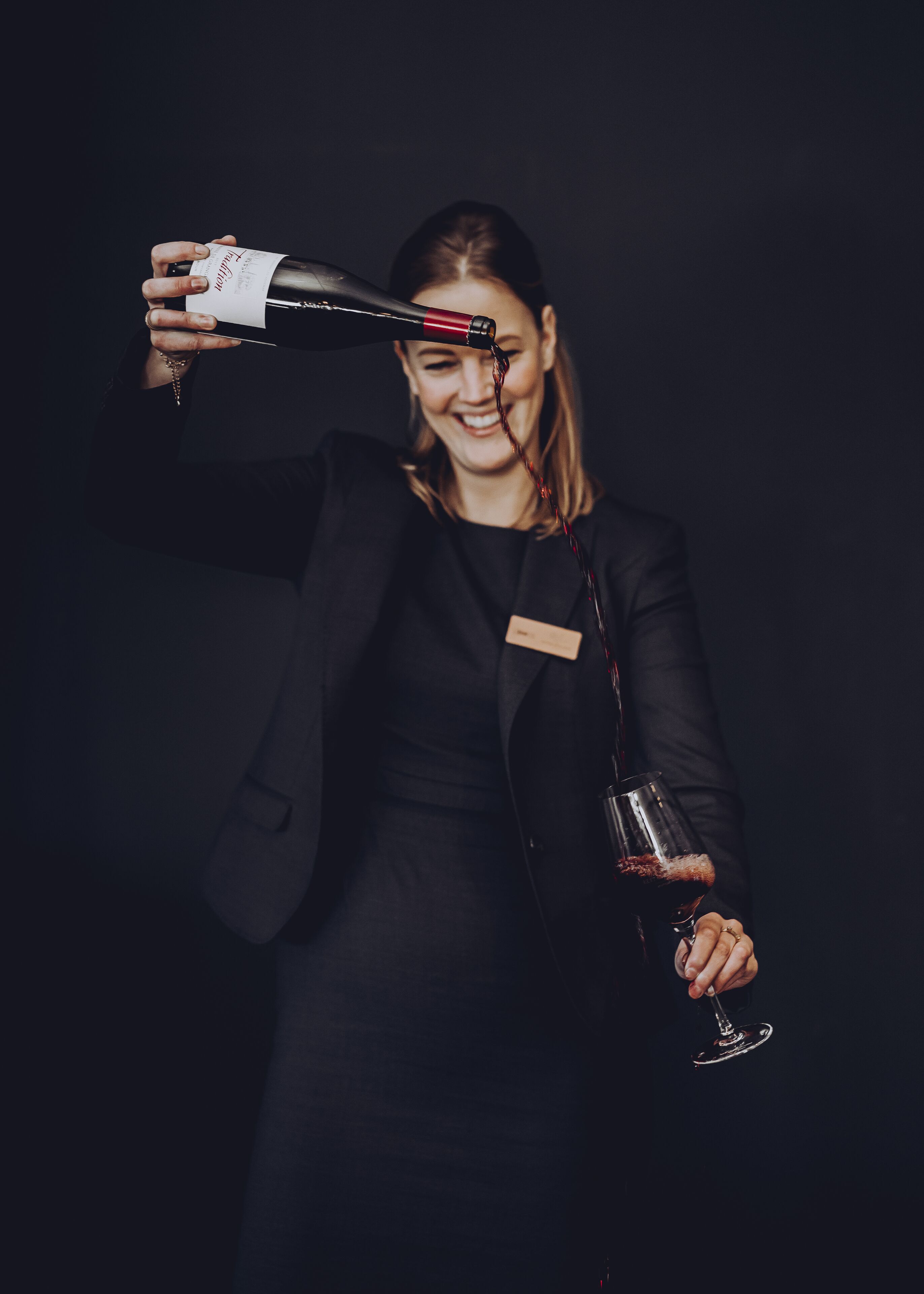 Una persona sirviendo vino en una copa.