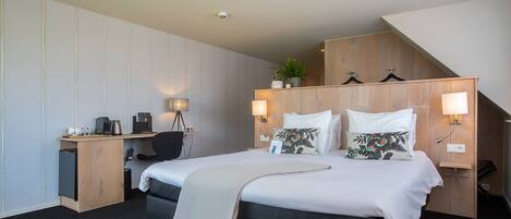 A hotel room with a bed, desk, and chair.