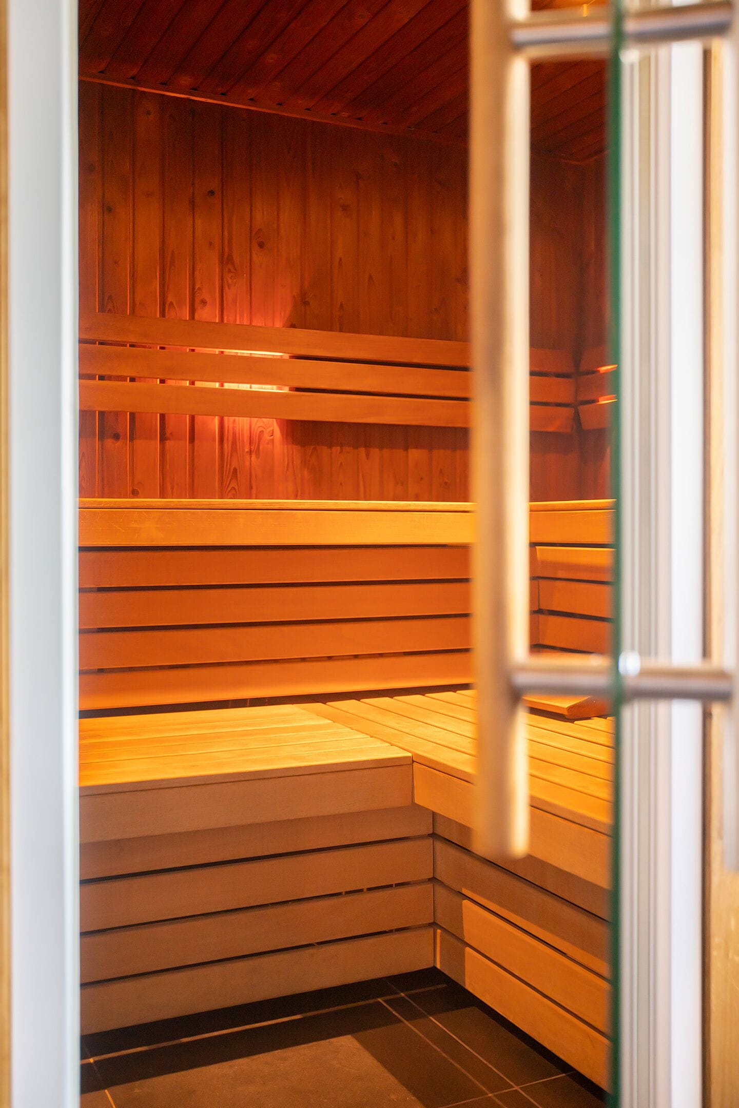A sauna with wooden benches and a tiled floor.