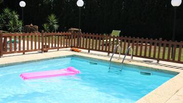 Enjoy a refreshing swim in our pool surrounded by lush greenery.