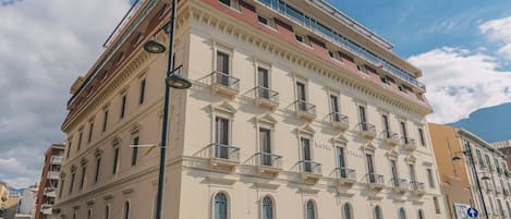 A multi-story hotel with a classic architectural style, featuring balconies and large windows.