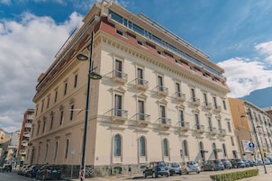Un hotel de varios pisos con un estilo arquitectónico clásico, que cuenta con balcones y ventanas amplias.